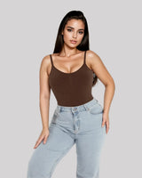 CYRA Bare-Back Sculpt Thong Bodysuit in Cocoa — front view on model, styled with jeans