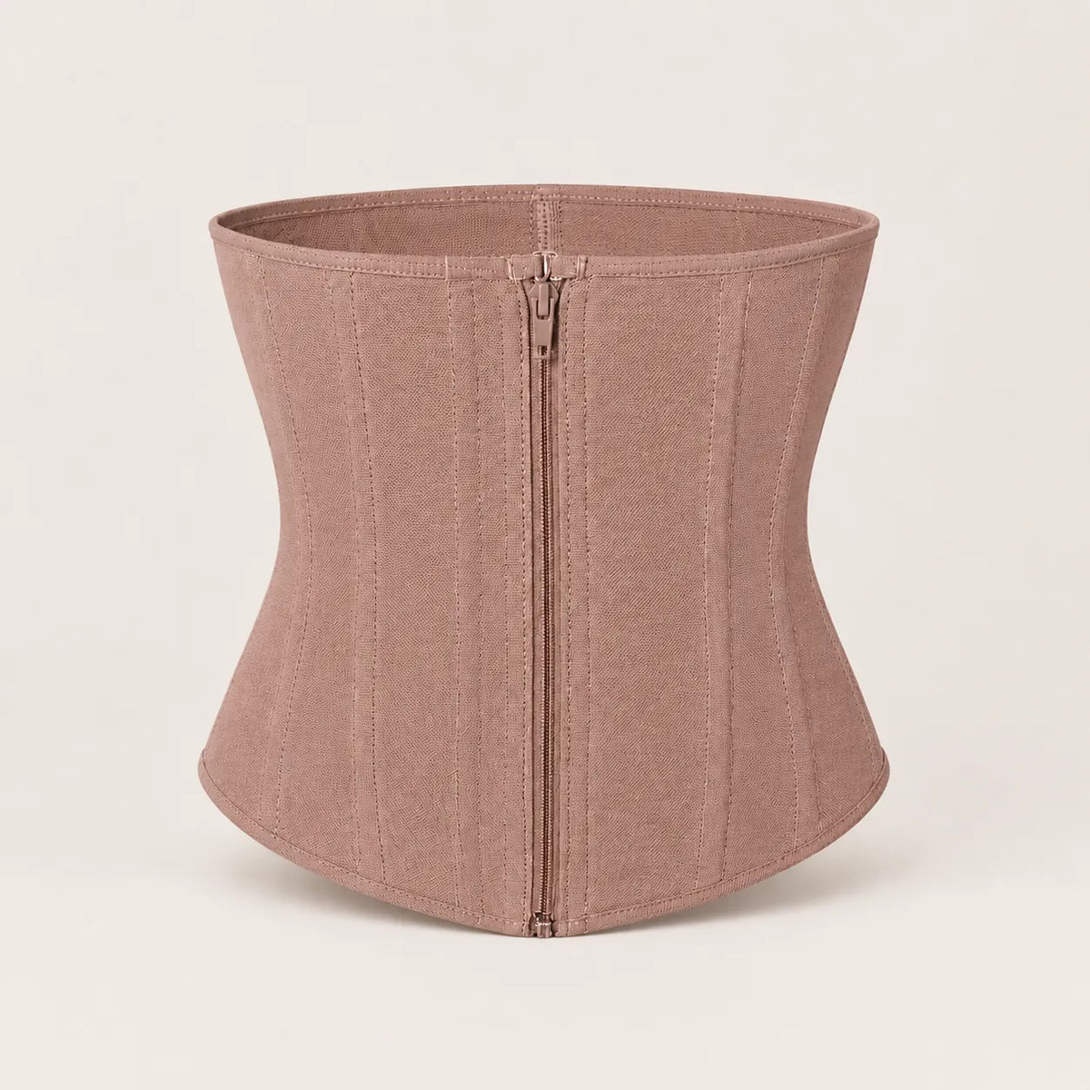 The Sculpt Waist Trainer in Latex-Free Sandstone, photographed off-body, showing the curved front panel and boned side seams